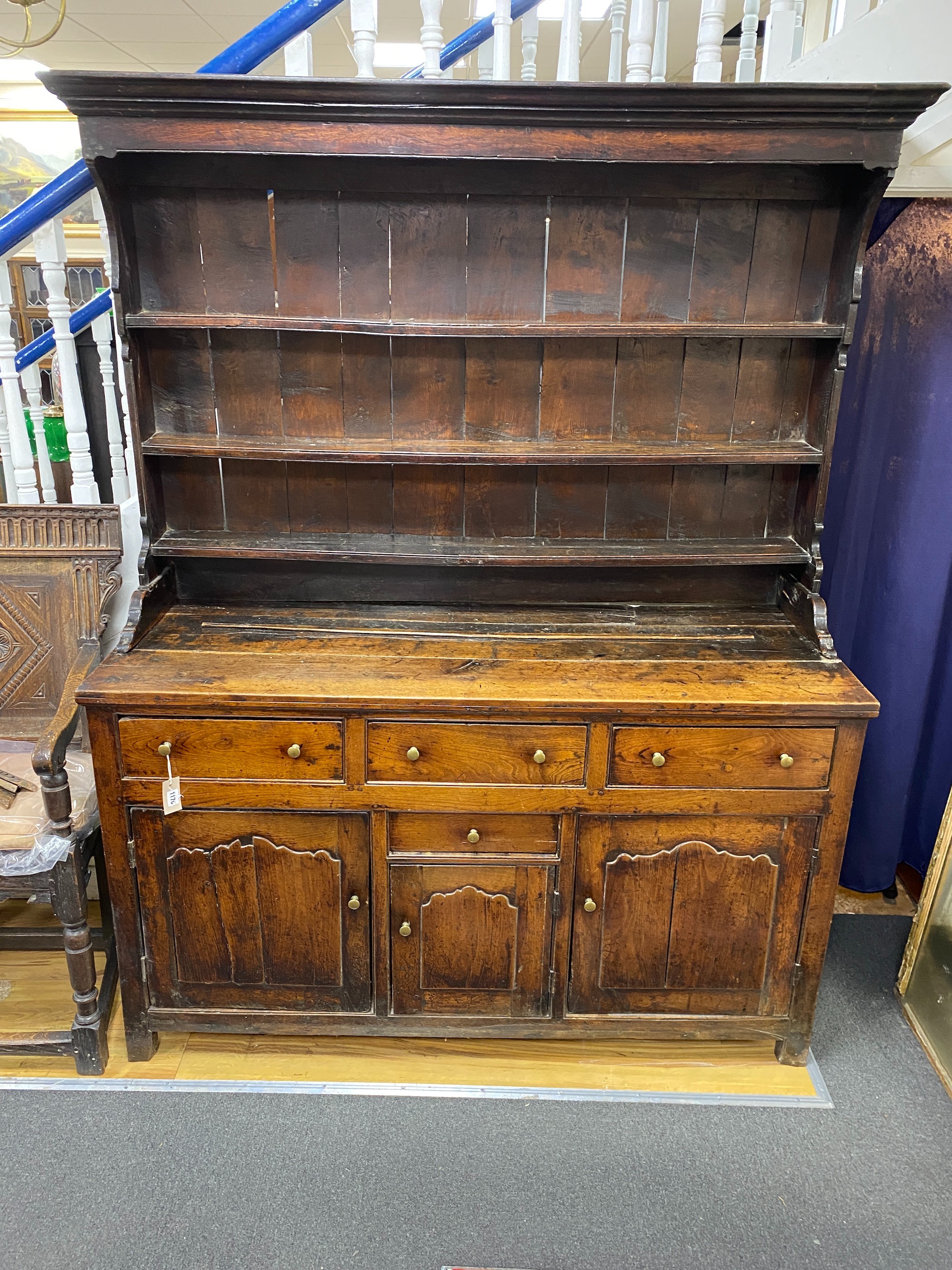 An 18th century oak dresser with boarded rack, length 149cm, depth 54cm, height 193cm